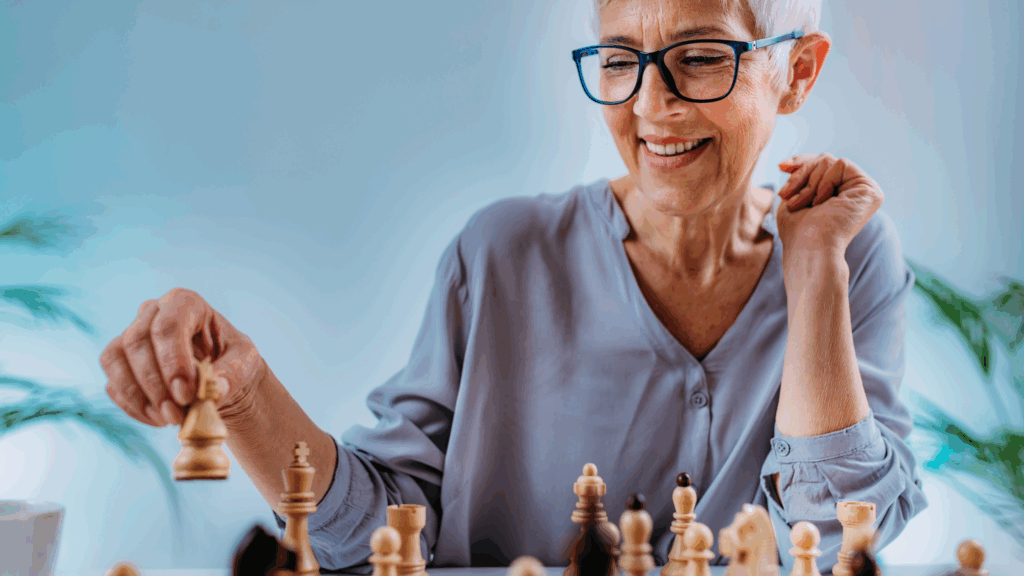 An older woman enjoys a game of chess, staying sharp and avoiding cognitive decline through mental stimulation.